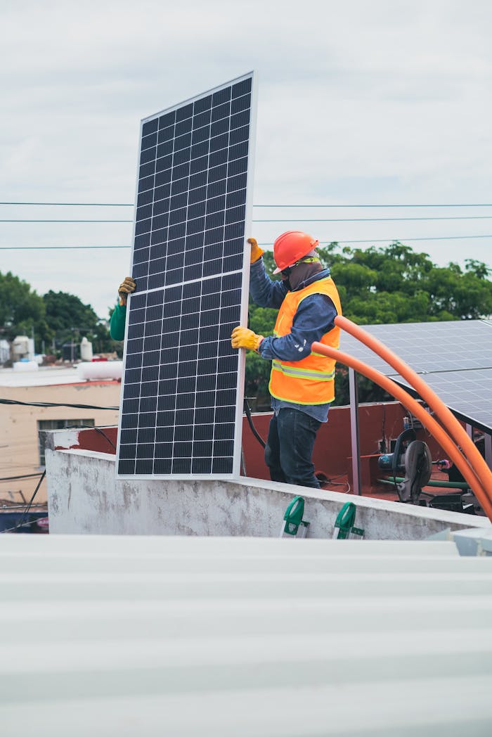 our-services-1 A technician in safety gear installs a solar panel on a rooftop, promoting renewable energy.
